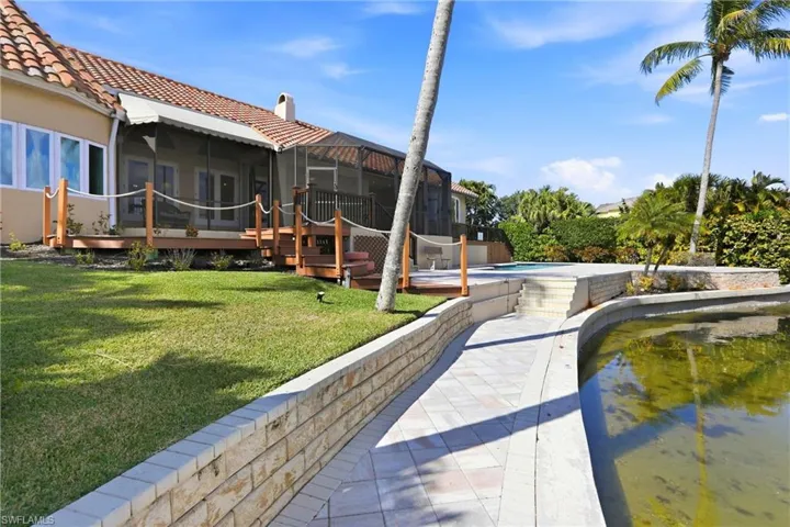 Rear view of property with a  a deck, screened lanai and an outdoor pool