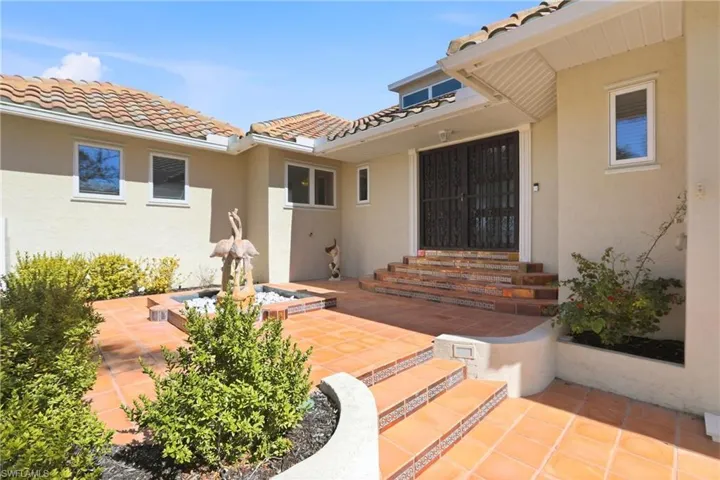 Entrer the home through a charming courtyard with a wrought iron gate and decorative fountain.