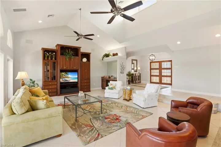 The spacious Living room provides ample room for entertaining, and features soaring ceilings, tile floors, dry bar and a wood burning fireplace.