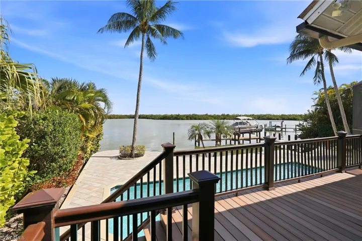 Deck with a water view, boat lift, and a dock