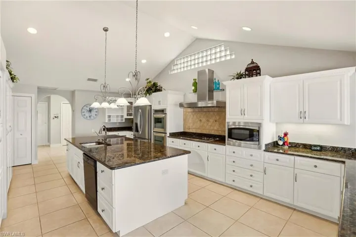 The gourmet Kitchen boasts ample white cabinetry with granite countertops, gas range and stainless steel finish appliances.