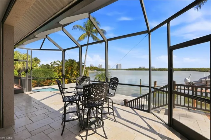 Screened lanai with pool, boat dock and bay view.