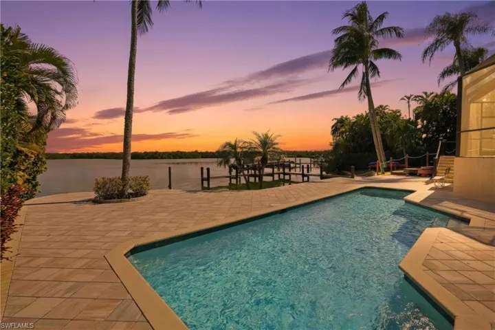 Pool at dusk with a patio area and an outdoor heated pool