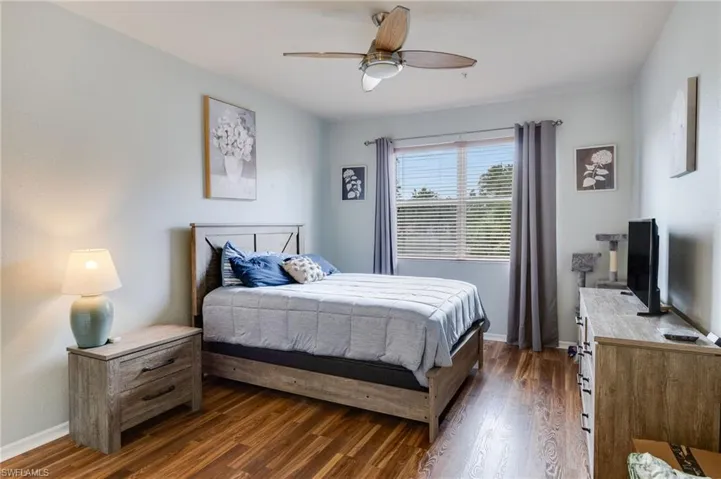 Bedroom featuring wood-finish flooring, a ceiling fan, and a window with blinds