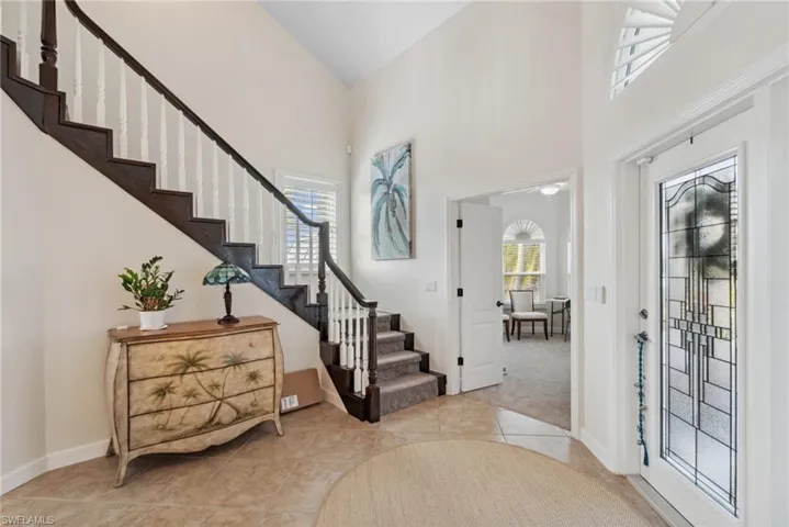 Foyer with light tile patterned floors and a high ceiling