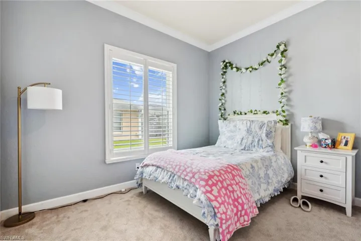Bedroom featuring light colored carpet and ornamental molding