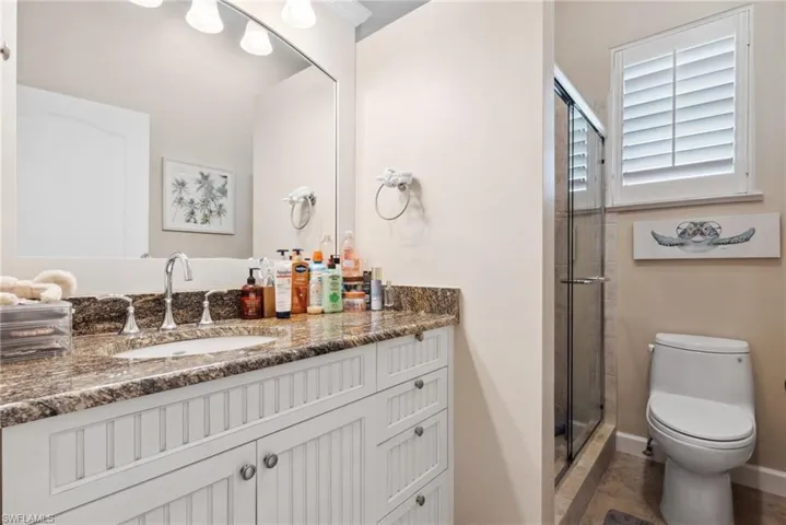 Bathroom with vanity, toilet, and walk in shower