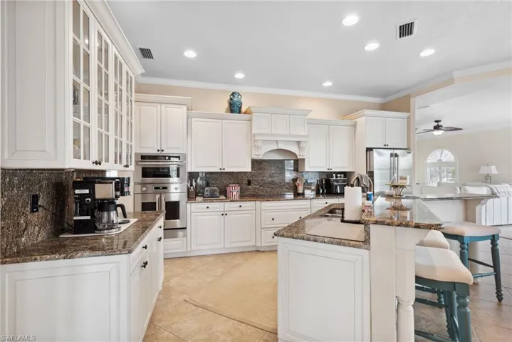 Kitchen with ceiling fan, white cabinets, stainless steel appliances, and light tile patterned floors