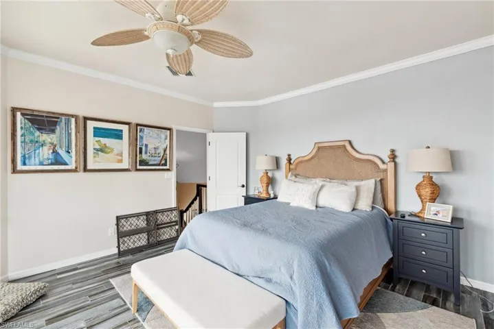 Bedroom featuring ceiling fan, dark hardwood / wood-style floors, and ornamental molding