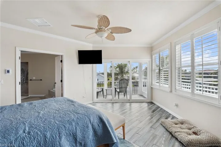 Bedroom with access to outside, ceiling fan, crown molding, and light hardwood / wood-style floors