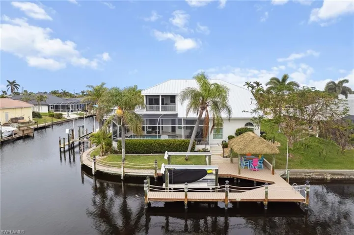 Dock area featuring a water view, a swimming pool, a lanai, a yard, and a balcony
