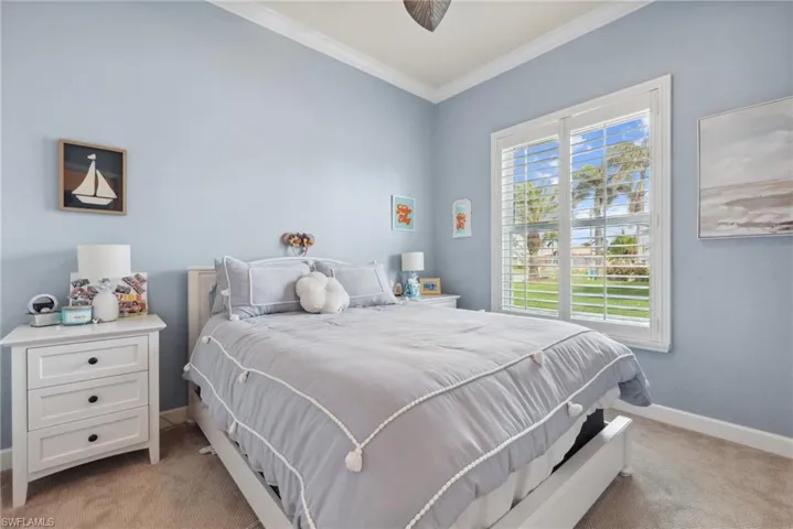 Bedroom with light colored carpet and crown molding