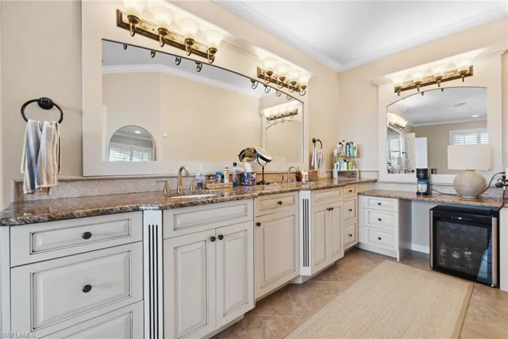 Bathroom with crown molding, tile patterned flooring, vanity, and beverage cooler