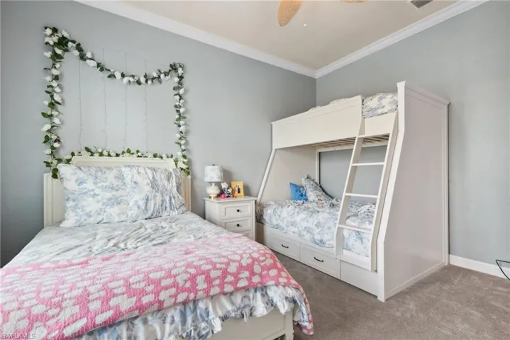 Bedroom featuring carpet, ceiling fan, and ornamental molding