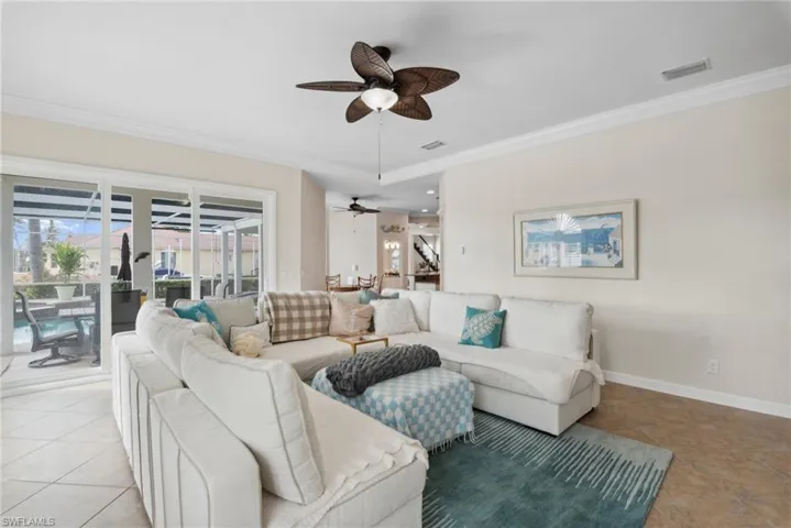 Living room with light tile patterned floors and crown molding