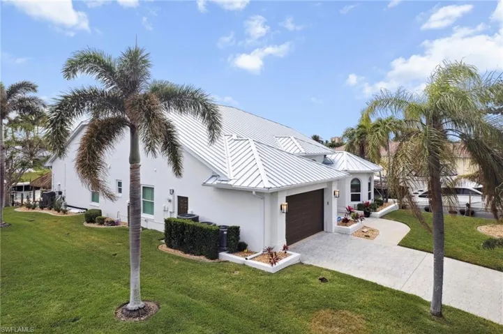 View of front of property with a garage and a front lawn