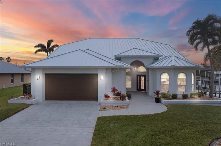 View of front facade featuring a lawn and a garage
