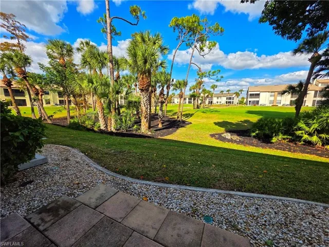 View of green lawn with a residential view