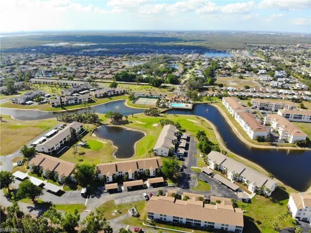 Aerial view of property's location featuring a nearby body of water and nearby suburban area