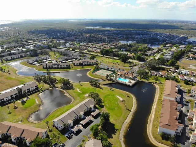 Aerial view of property and surrounding area with a large body of water, nearby suburban area, and a golf club