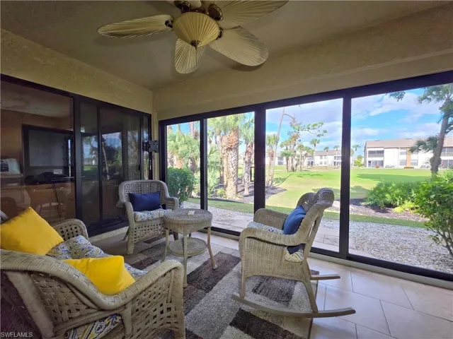 Sunroom / solarium with a residential view, golf course view, and tile patterned flooring