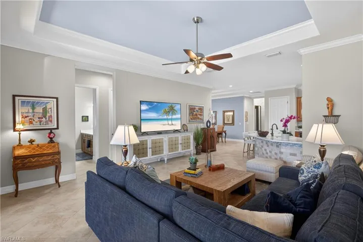 Tiled living room with a ceiling fan, ornamental molding, and recessed lighting