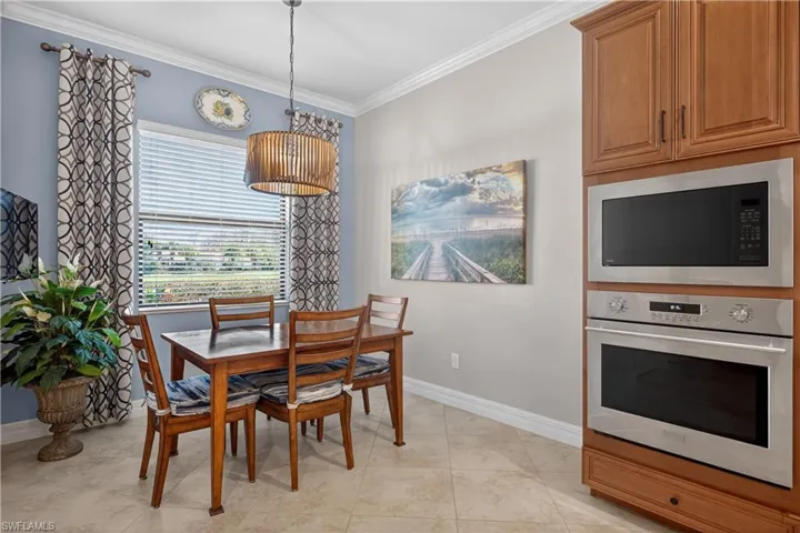 Dining space featuring ornamental molding and light tile patterned flooring