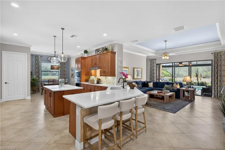 Kitchen with a kitchen island, wood finish cabinets, ceiling fan, a peninsula, and a breakfast bar