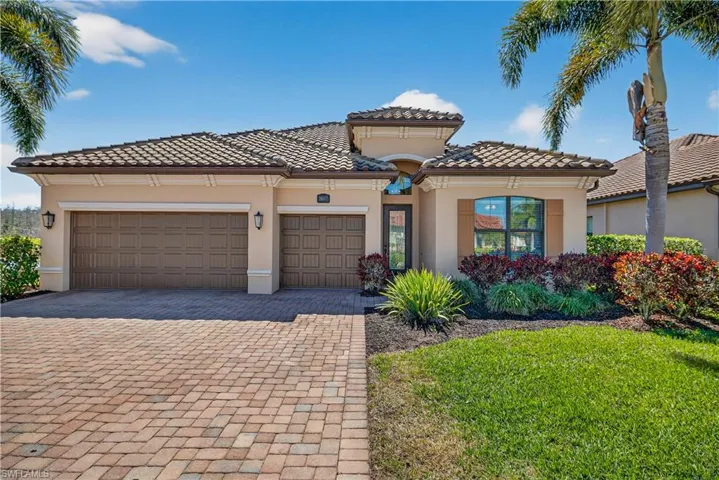 Mediterranean / spanish-style house featuring decorative driveway, stucco siding, a garage, and a front lawn