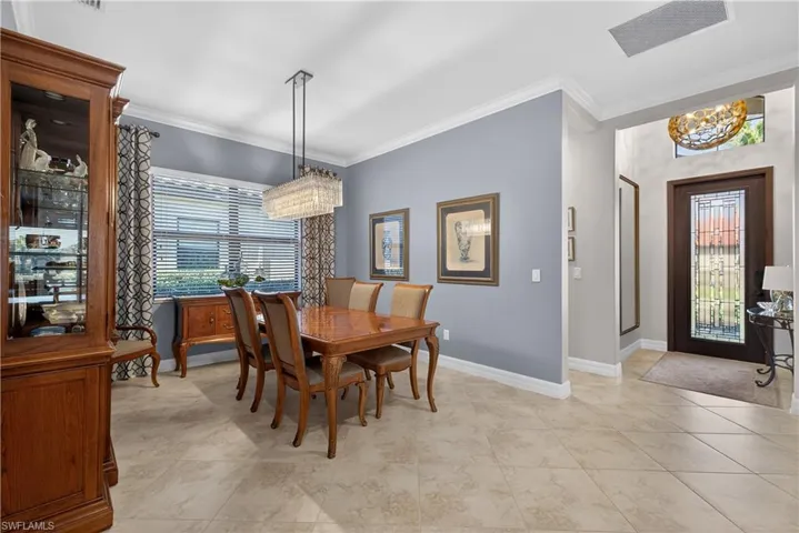 Dining area featuring hanging lights, crown molding, and healthy amount of natural light