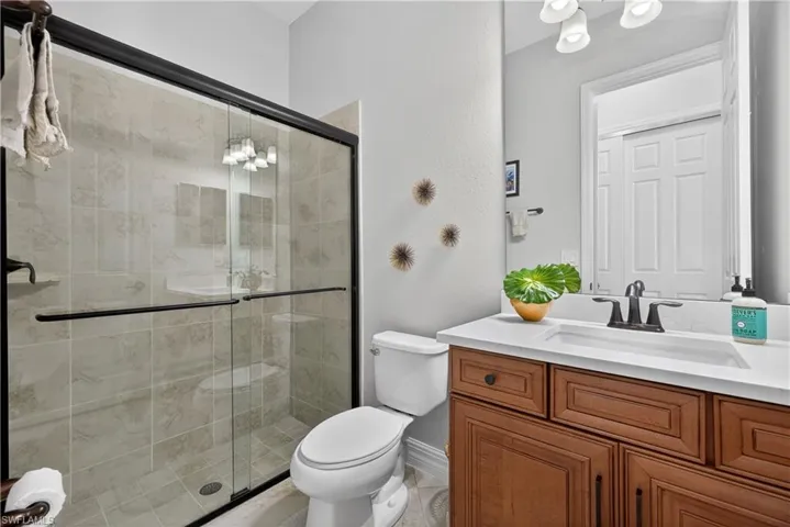 Full bath with suspended lighting, vanity, and a stall shower