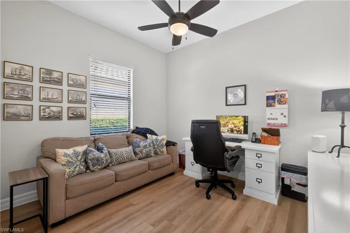 Home office with light wood-style floors and ceiling fan