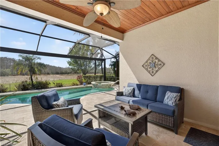 View of patio with outdoor lounge area, a sunroom, glass enclosure, a ceiling fan, and a pool with connected hot tub