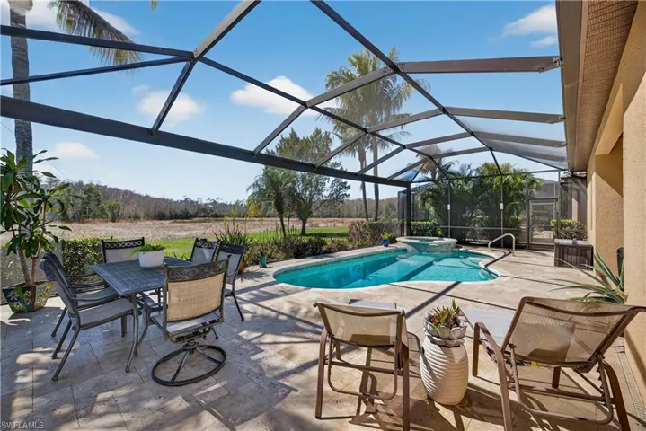 Combined pool / hot tub featuring a patio, a sunroom, glass enclosure, and outdoor dining area