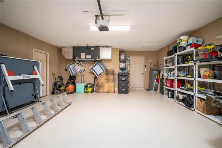 Garage with gas water heater and a garage door opener