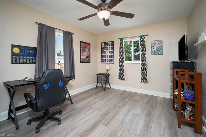 Home office with light hardwood / wood-style floors and ceiling fan
