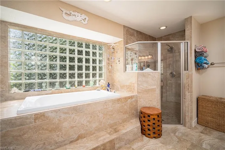 Bathroom featuring tile patterned floors and shower with separate bathtub