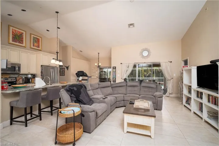 Tiled living room with high vaulted ceiling and a chandelier
