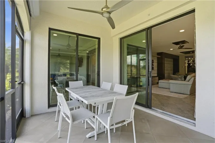 Sunroom with outdoor dining area, ceiling fan, and a patio