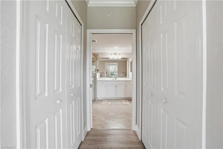 Hallway featuring ornamental molding and light wood-style flooring