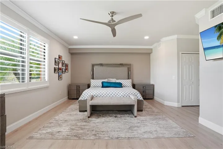 Bedroom with a ceiling fan, light wood-type flooring, ornamental molding, and recessed lighting