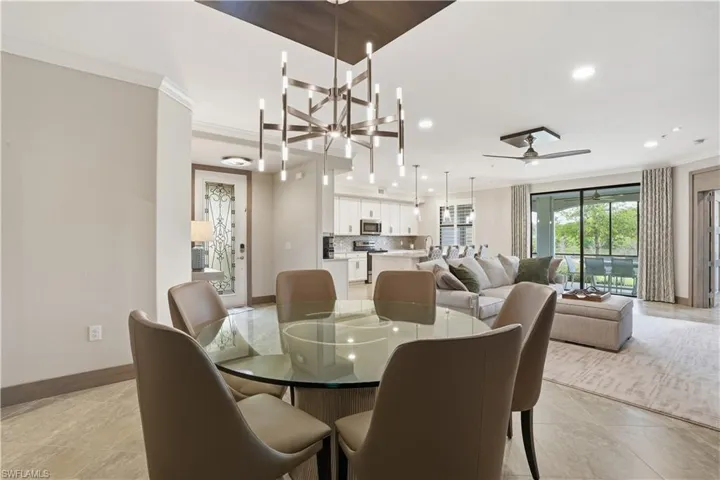 Dining space with crown molding, hanging lights, and ceiling fan