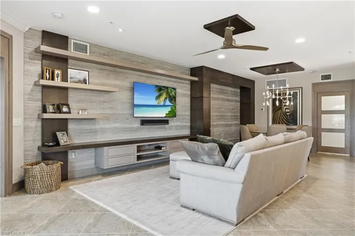 Living area featuring ceiling fan, a chandelier, and light tile patterned floors