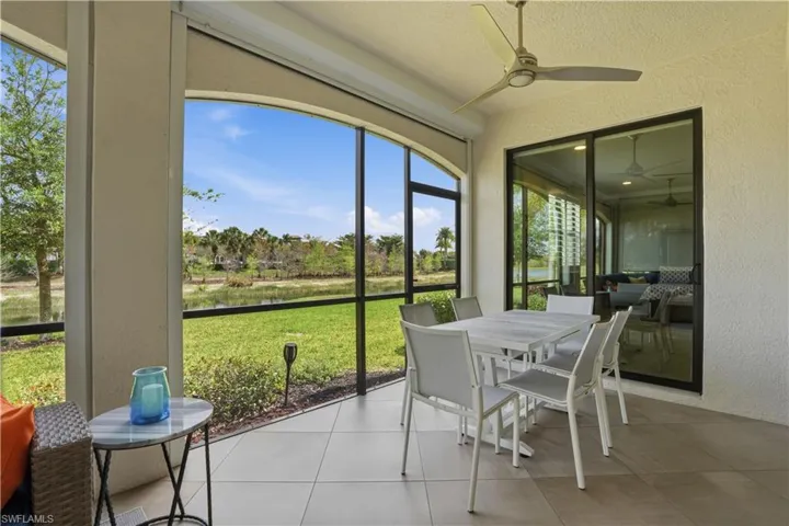 Sunroom / solarium featuring outdoor dining area and a ceiling fan