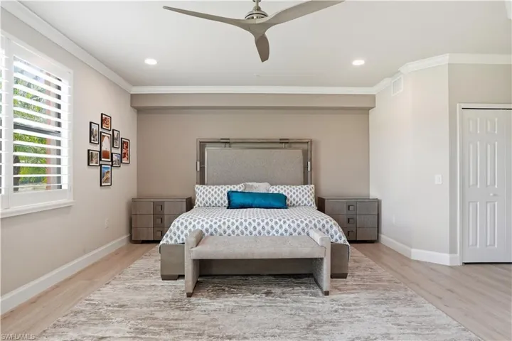 Bedroom with a ceiling fan, light wood-type flooring, ornamental molding, and recessed lighting