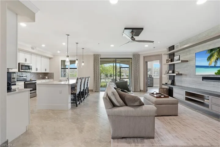 Living room with a ceiling fan, ornamental molding, and recessed lighting