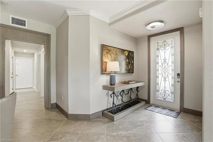 Entryway featuring crown molding and light tile patterned floors