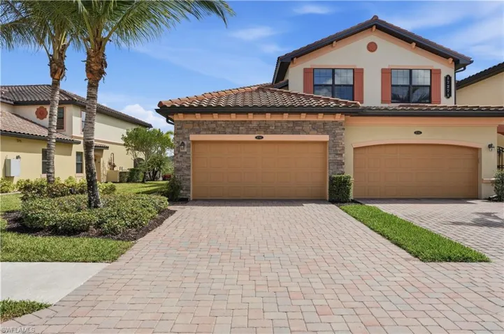 Mediterranean / spanish-style home with decorative driveway, stucco siding, stone siding, and a tile roof