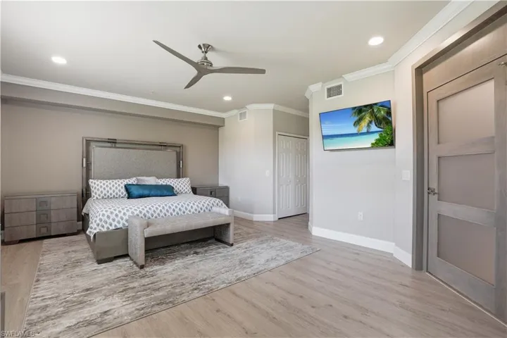 Bedroom featuring a ceiling fan, light wood-style flooring, ornamental molding, recessed lighting, and a closet