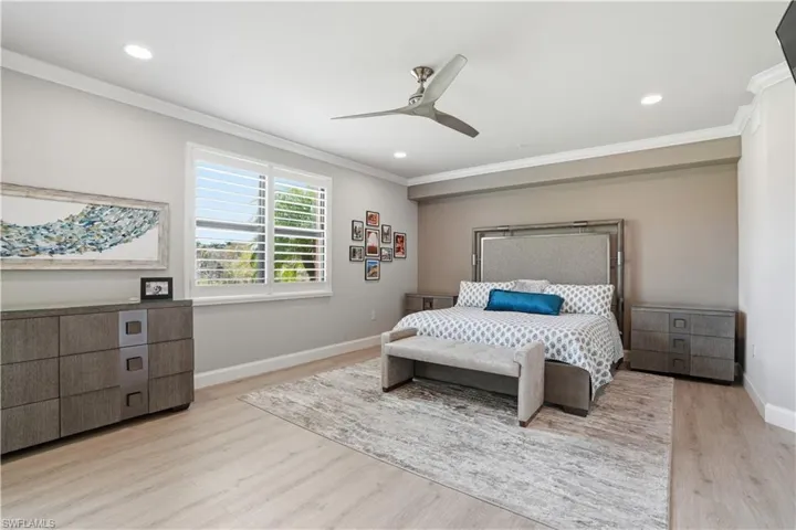 Bedroom with ornamental molding, light wood-style flooring, a ceiling fan, and recessed lighting